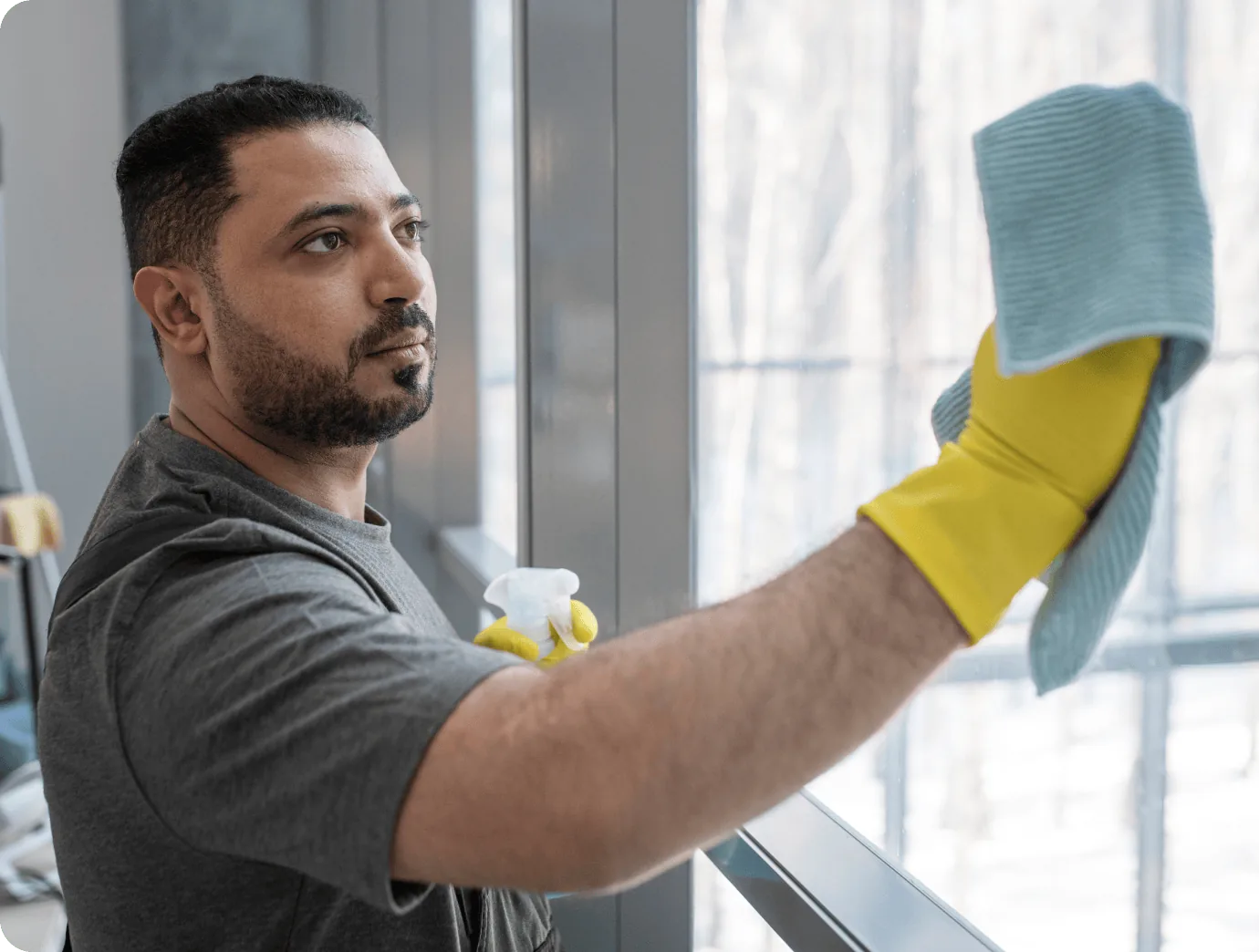 A JoyShine team member cleaning an office window